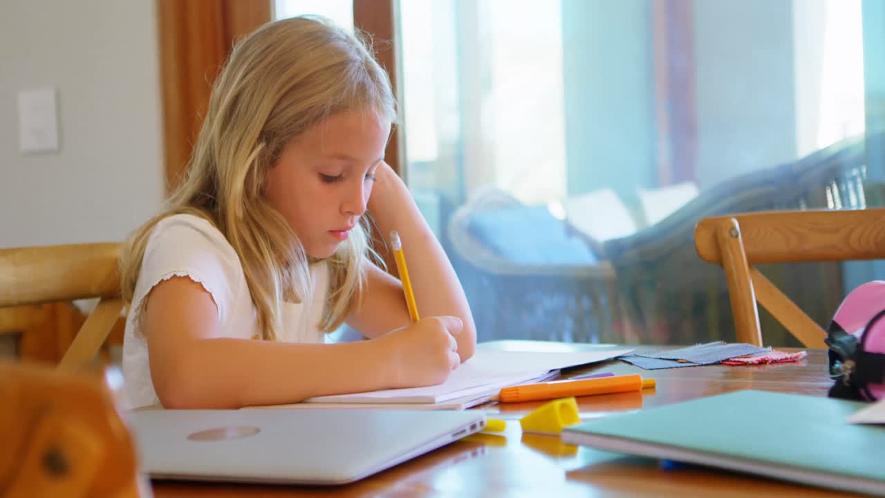Girl doing her homework at home 4k