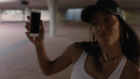 bailarina de calle feliz con auriculares disfrutando de escuchar música hip hop usando un teléfono inteligente realizando movimientos de baile de estilo libre en la ciudad