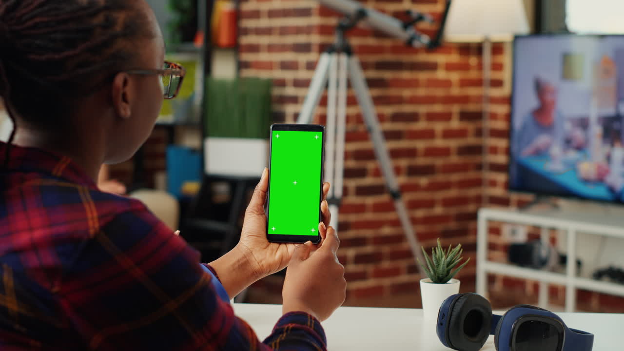 African american woman vertically holding telephone with greenscreen