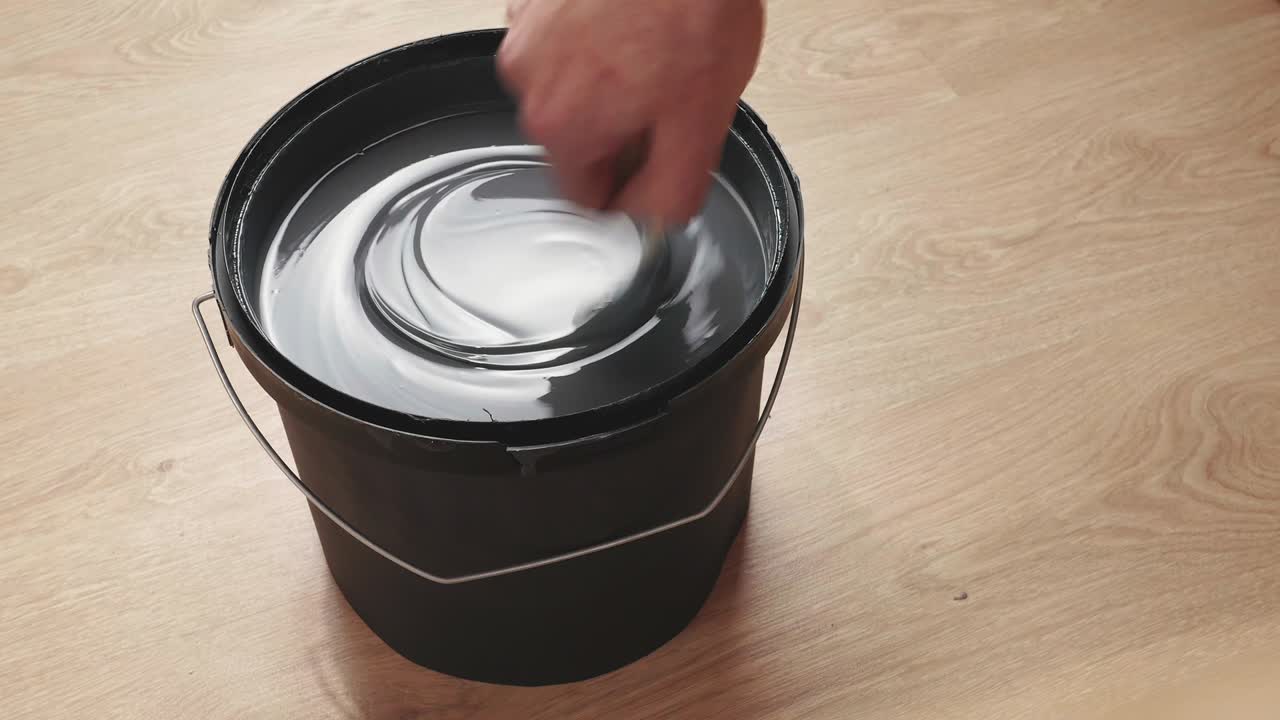 mezclando pintura gris en una lata. preparándose para pintar las paredes.
