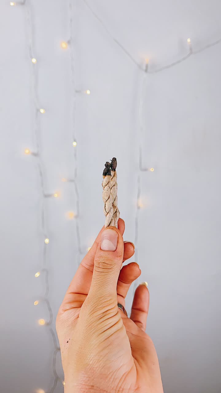 Hand holding burning incense sticks