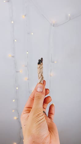 mano con palos de incienso en llamas