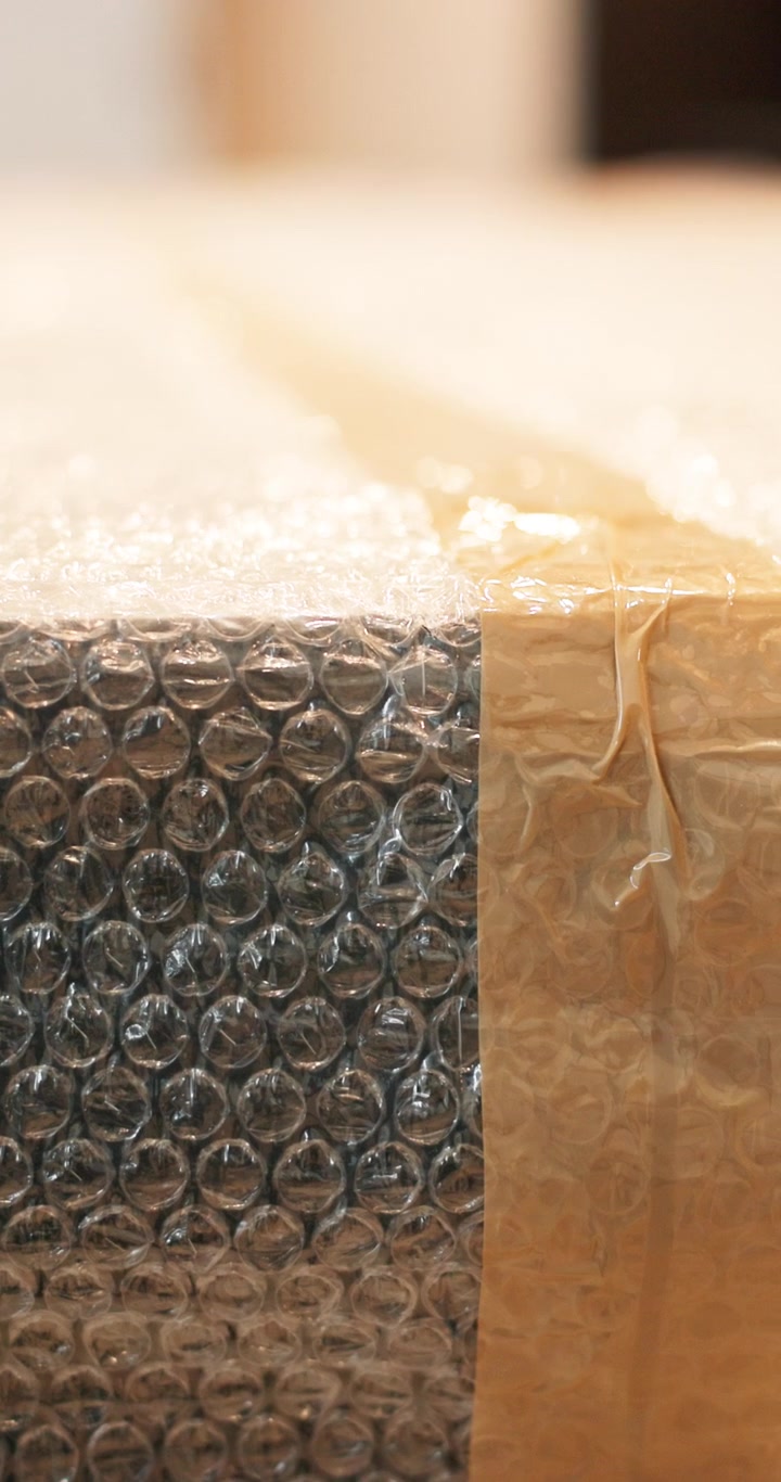 Tampak Dekat Kotak Kardus yang Dibungkus Bubble Wrap Pelindung