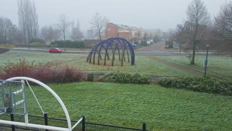 Low-aerial-of-car-driving-over-road-in-a-misty-suburban-neighborhood