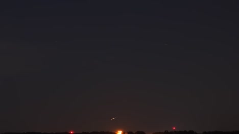 a time lapse taken on an airport, at night. lights and stars move across the clear skies.