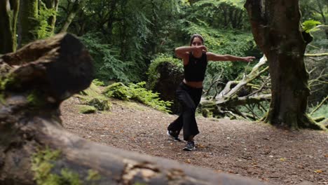 Joyful-teenage-latina-practicing-capoeira-in-meadow