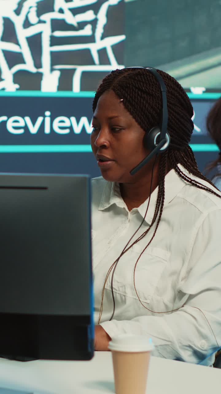Afroamerikansk kvinne som jobber i callsenter med headset
