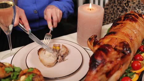 mujer cortando un lomo de cerdo rostido en una cena de vacaciones