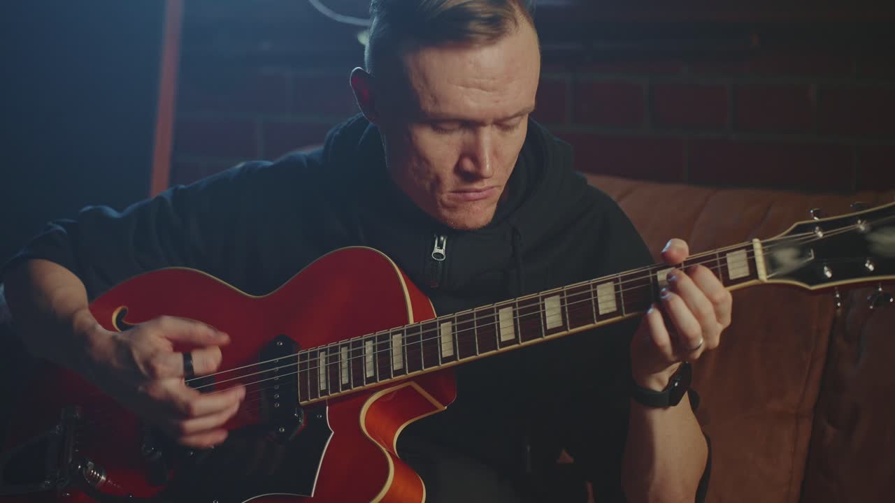 Man Playing a Red Jazz Guitar