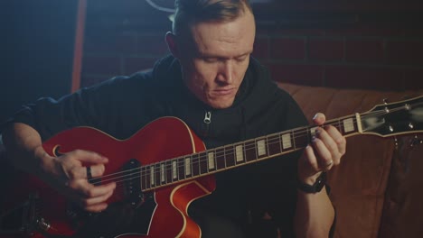 man playing a red jazz guitar