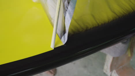 primer plano de la cinta de enmascarar de pelado del artesano después de aplicar el color de doble tono en el tablero de madera