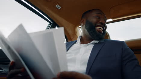 Man-analysing-documents-at-car