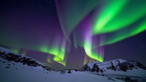 aurora boreal sobre las montañas nevadas