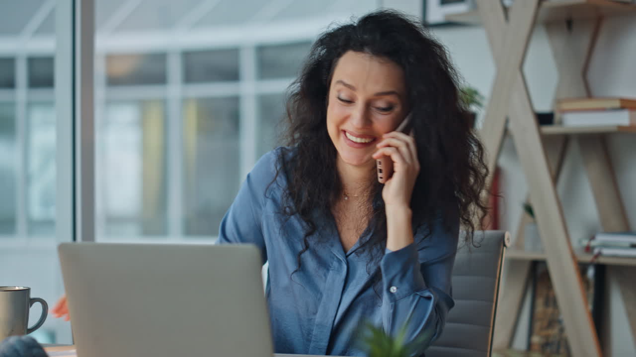 Happy worker calling smartphone in evening office. Joyful executive discussing