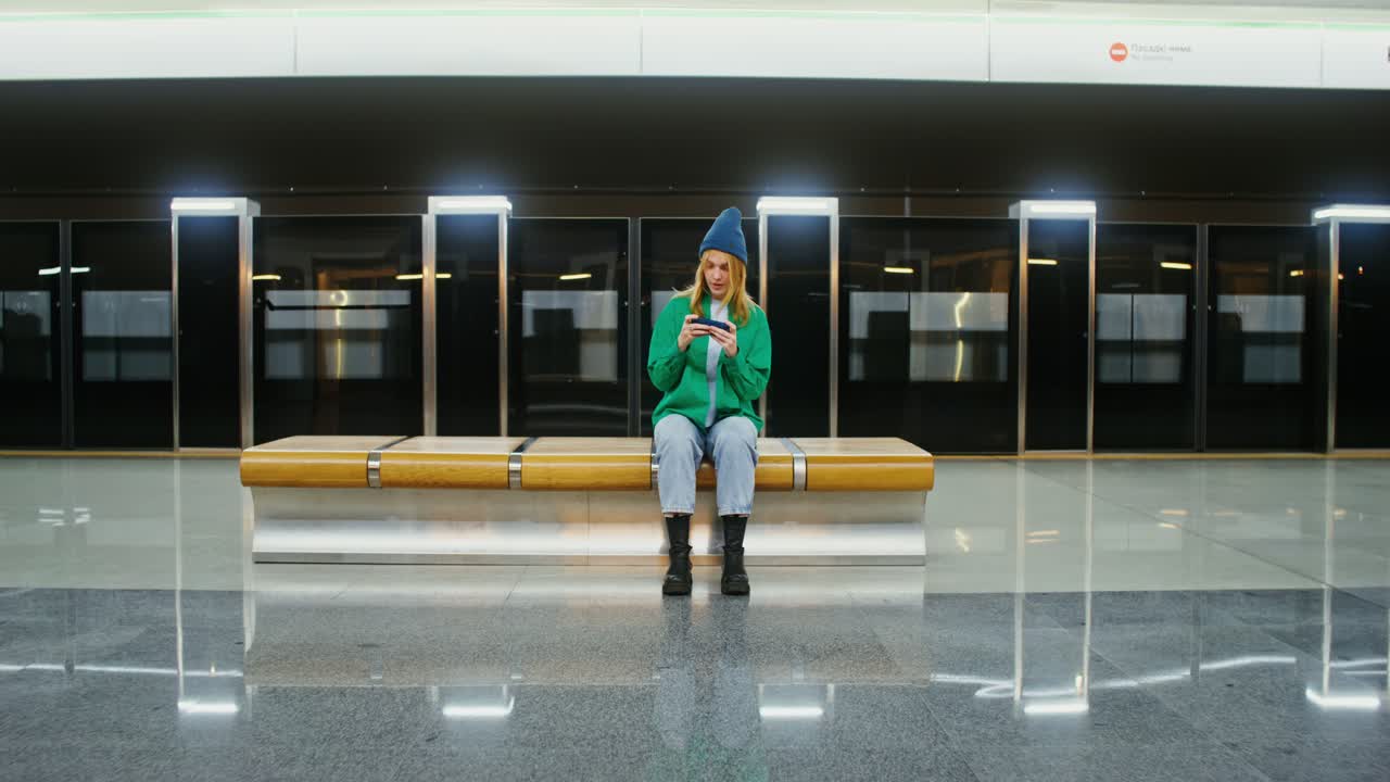 Woman using phone at a subway station