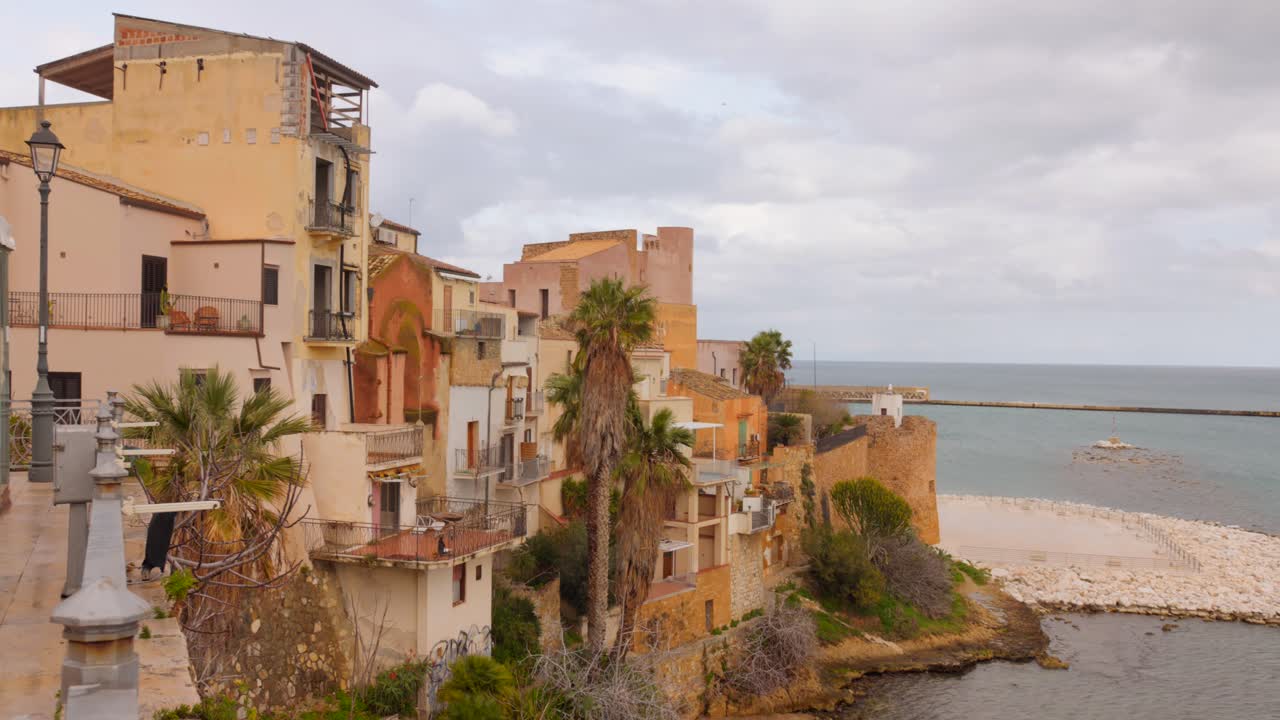 Discover the charm of Castellammare del Golfo's historic town center, featuring coastal views, elegant architecture, and vibrant local culture under a soft, cloudy sky.