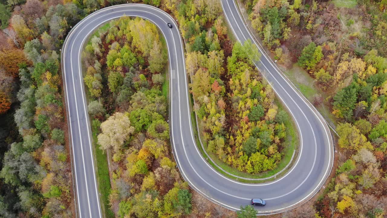 los coches viajan por el camino de la montaña en el bosque de otoño, el follaje de otoño bosques paisaje aéreo