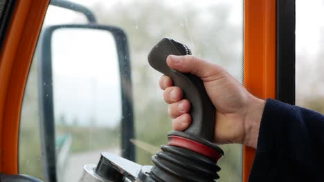 male hand controls joystick of excavator machine