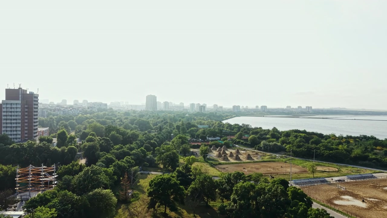 Vista dello skyline della città con alberi verdi lungo la riva del fiume ed edifici in lontananza durante il giorno.
