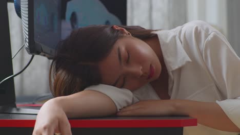 아시아 여성 자동차 디자이너가 스튜디오의 데스크 컴퓨터에서 ev 자동차의 3d 모델을 작업하는 동안 잠을 자고있는 근접 측면 뷰