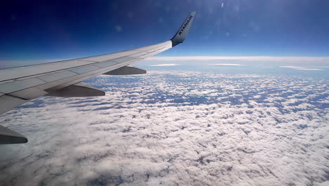 una toma de punto de vista suave de un perfil aéreo desde un ojo de buey de una aeronave por encima de un paisaje nuboso