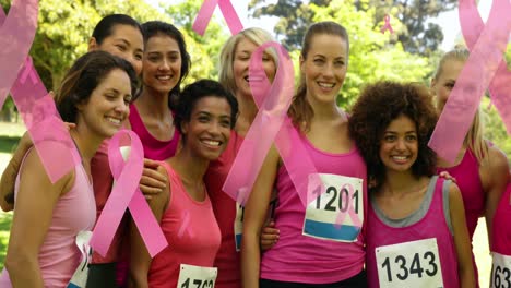 animation of pink ribbon and anchor logos, floating over smiling group of diverse female runners