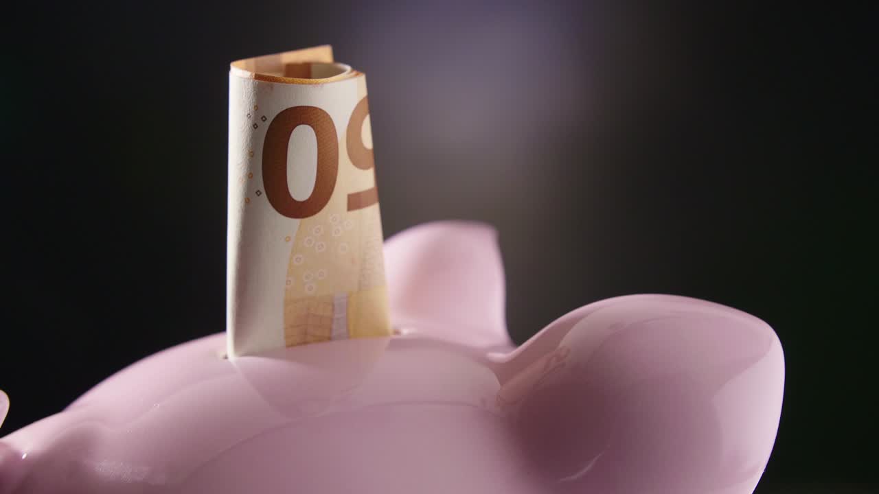 Nahaufnahme von 50 Euro im Sparschwein auf Drehteller