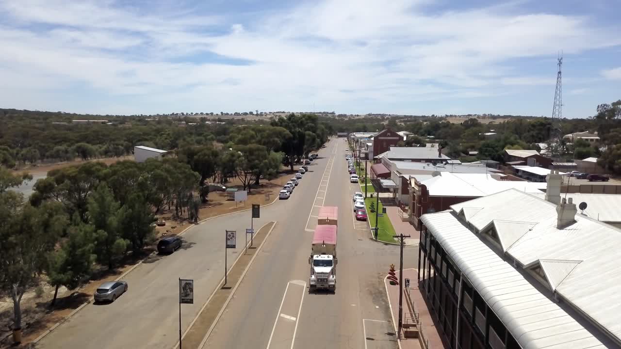 메인 스트리트를 굴러가는 트럭이 있는 작은 농업 공동체의 공중 전망