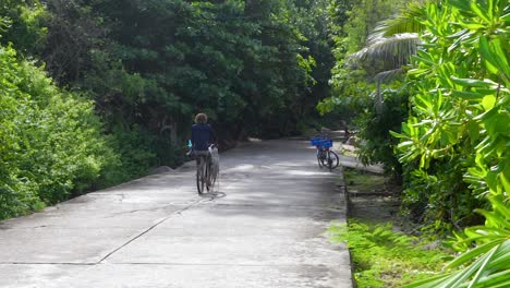 Pescador-De-Lanza-De-Pulpo-En-La-Digue,-Una-Isla-En-Las-Seychelles,-Se-Marcha-Con-Su-Captura-En-Una-Bicicleta