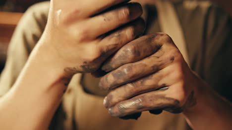 close-up view of hands working with clay