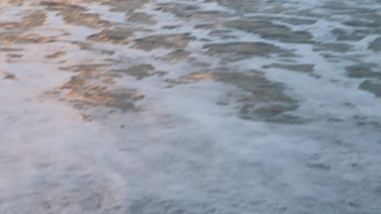 Panning view of sea waves on the shore. Close-up. Daylight