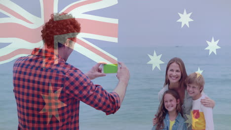 Taking-photo-of-smiling-family-on-beach,-Australian-flag-animation-over-scene