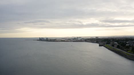 Just-after-sunrise-looking-over-a-city-docks-to-the-clouds-and-orange-sky-beyond-|-Edinburgh,-Scotland-|-4k-at-30-fps