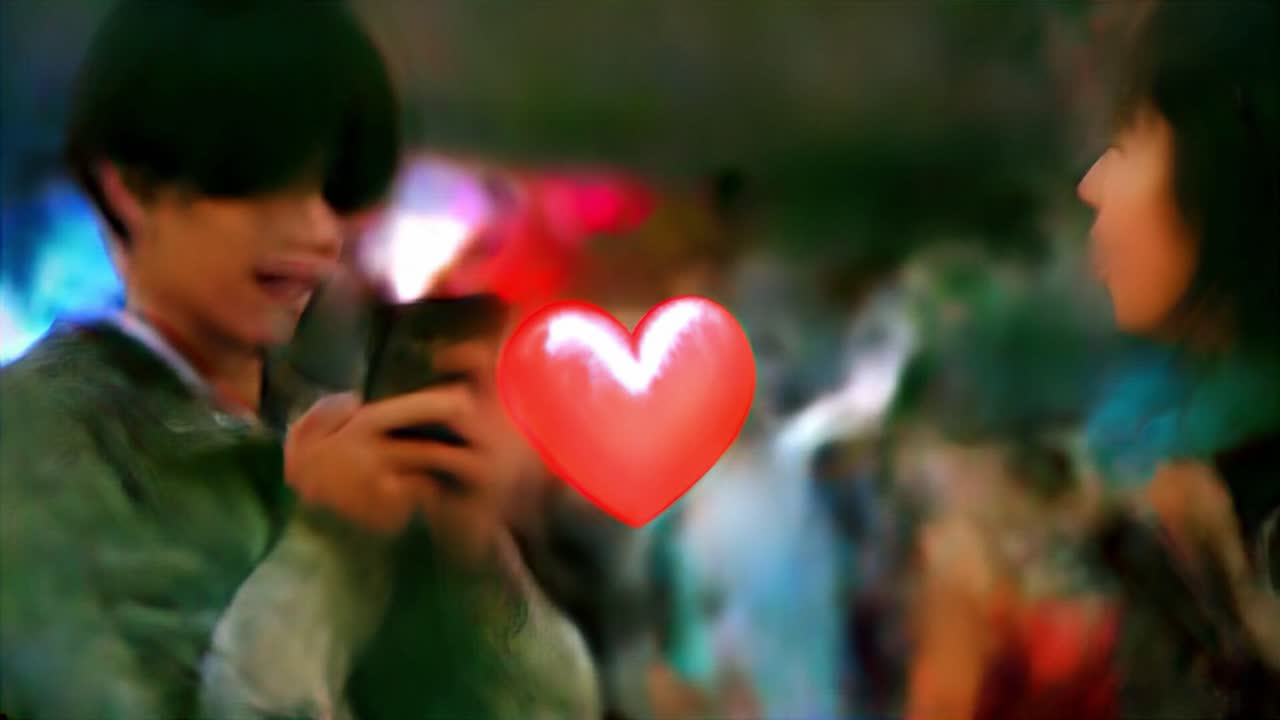 젊은 부부가 도시 야시장에서 휴대전화로 상호 작용하고 있습니다.