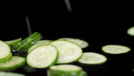 round slices of fresh cucumber fall to the water with a splash.
