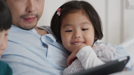 Glückliche-Asiatische-Familie,-Die-Zu-Hause-Einen-Tablet-Computer-Nutzt,-Mutter-Und-Vater-Mit-Kindern,-Die-Sich-Unterhaltung-Ansehen,-Ein-Spiel-Auf-Einem-Touchscreen-Gerät-Spielen,-Lernen,-Spaß-Haben-Und-Sich-Im-Bett-Entspannen,-4K-Videos