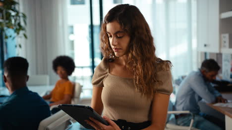 Portrait-Of-Young-Smiling-Businesswoman-With-Digital-Tablet-Standing-And-Working-In-Modern-Office