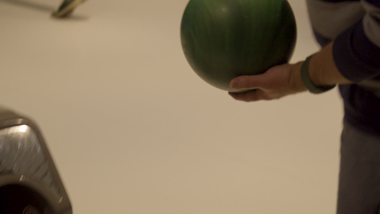 bola de boliche saliendo del sistema de retorno y siendo agarrada por el hombre