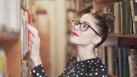 woman looking for a book in a library