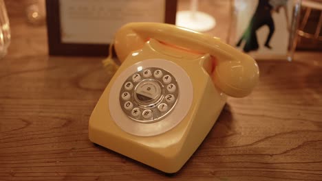 retro yellow rotary phone adds charm to wedding decor on rustic wooden surface