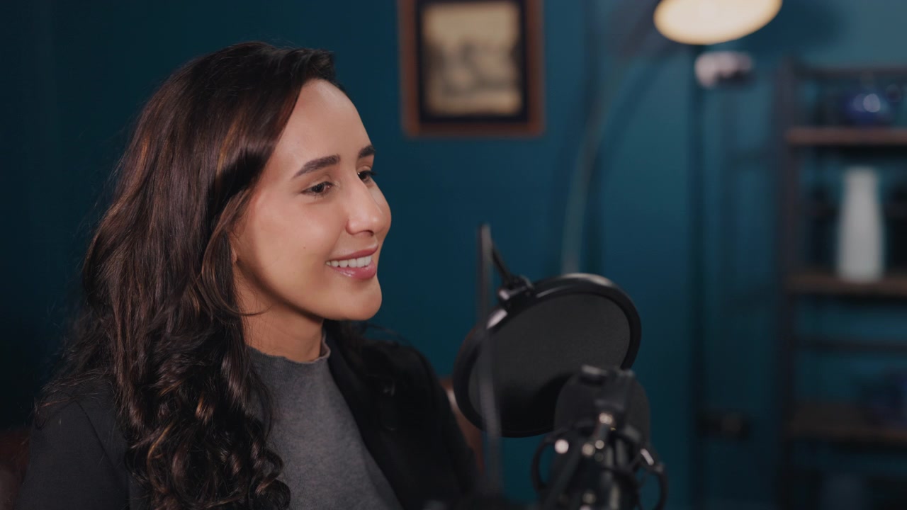 Giovane donna che parla al microfono durante la registrazione di un podcast.
