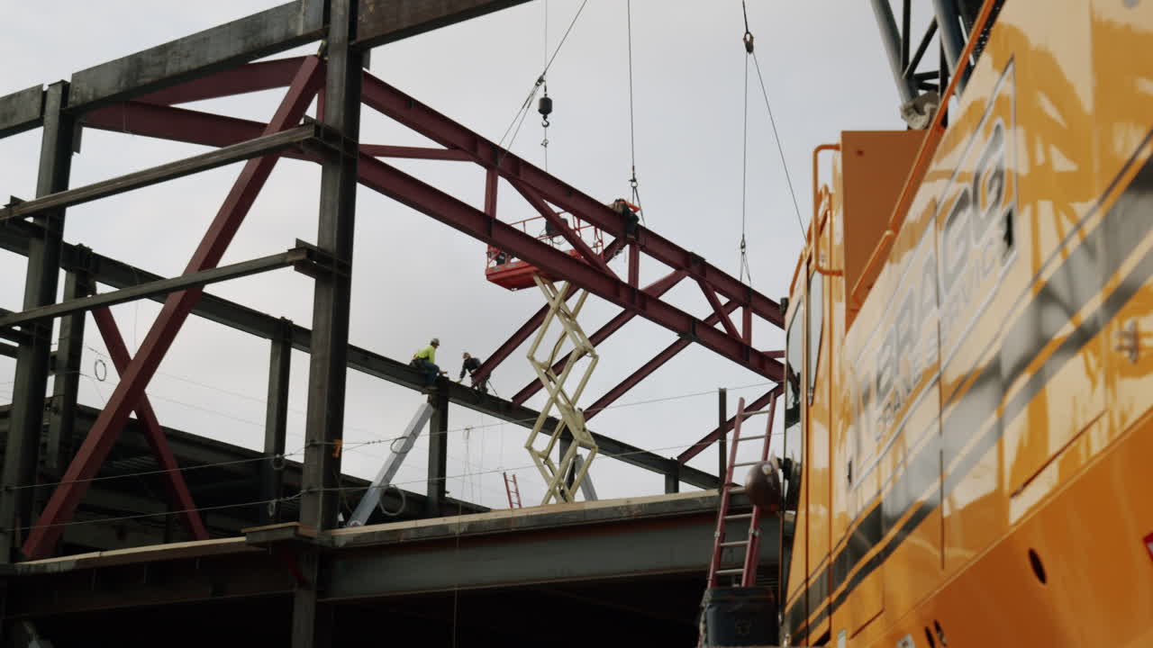 Construction site with steel framework, workers, and heavy machinery