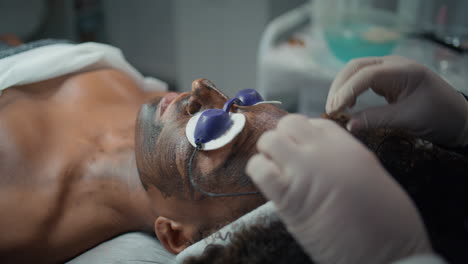 cosmetician hands put glasses on patient closeup. woman preparing procedure