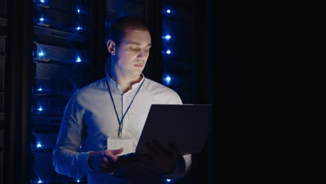 a computer engineer looks at and fixes server room problems. modern it specialist works in a cloud storage system