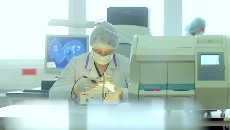 Scientist-looks-at-object-under-magnifying-glass-with-laboratory-equipment