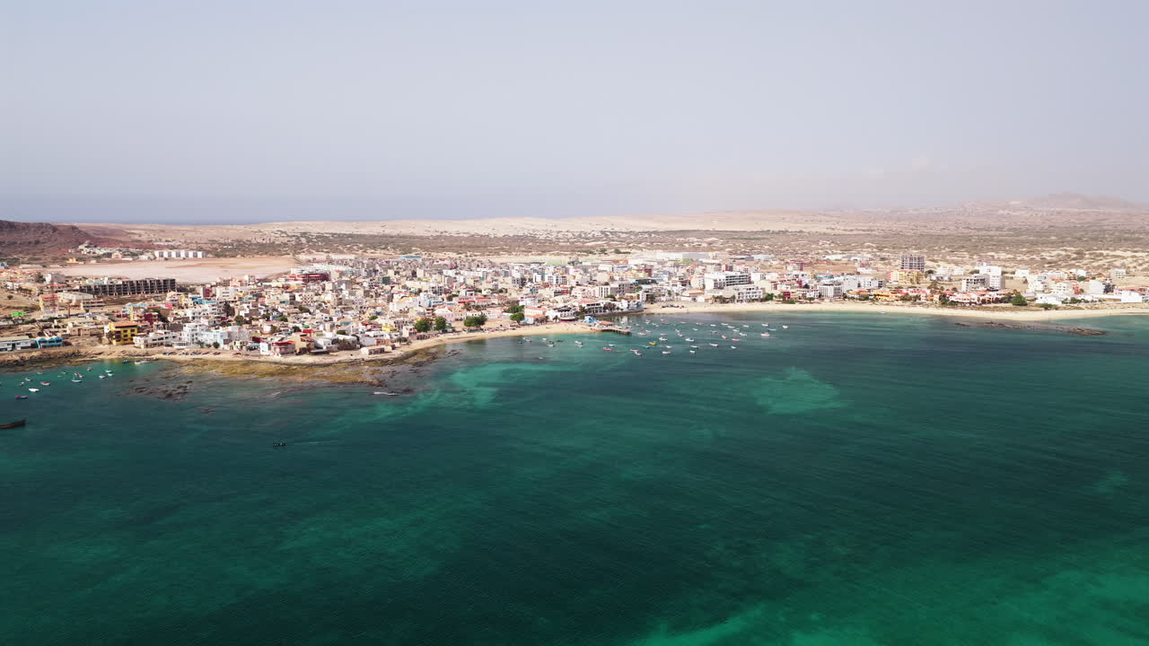Sal Rei city drone view, Old city with many colorful house, small port, turquoise ocean and sandy beach, background the desert,Boa Vista, Cape Verde