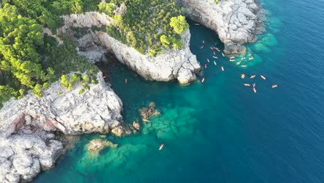 aerial view of a group of tourists on kayaks passing by lokrum island near dubrovnik on the adriatic coastline of croatia