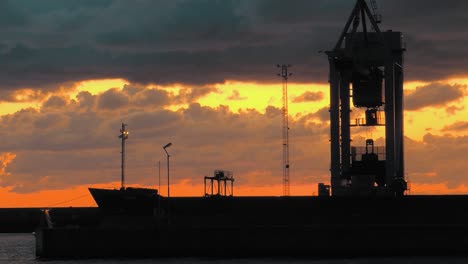 time-lapse with a cargo ship and a crane in the foreground on the coast of sweden