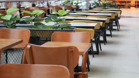 empty modern restaurant with wooden tables and yellow chairs