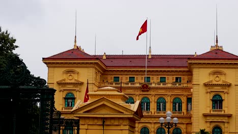 vietnamese flag being raised at hanoi palace